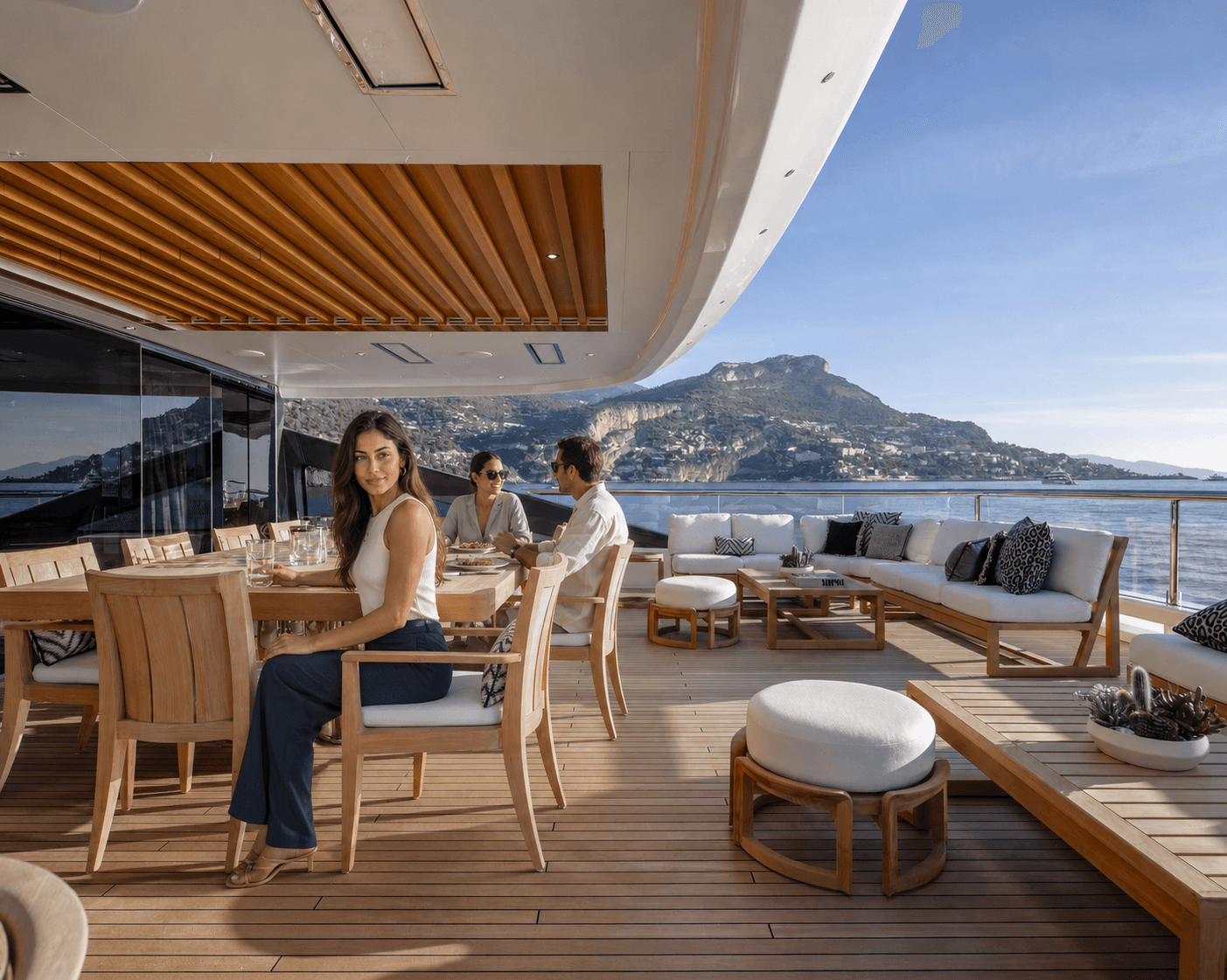 Guests dining on a yacht deck beside the water