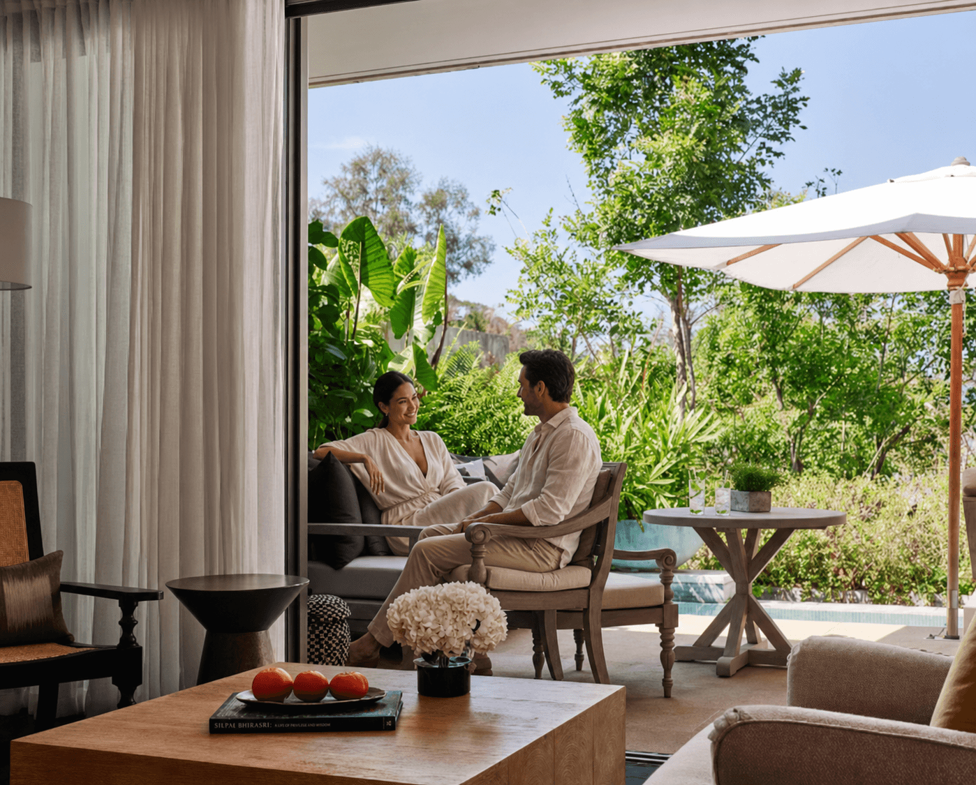 Couple relaxing outside a tropical hotel suite